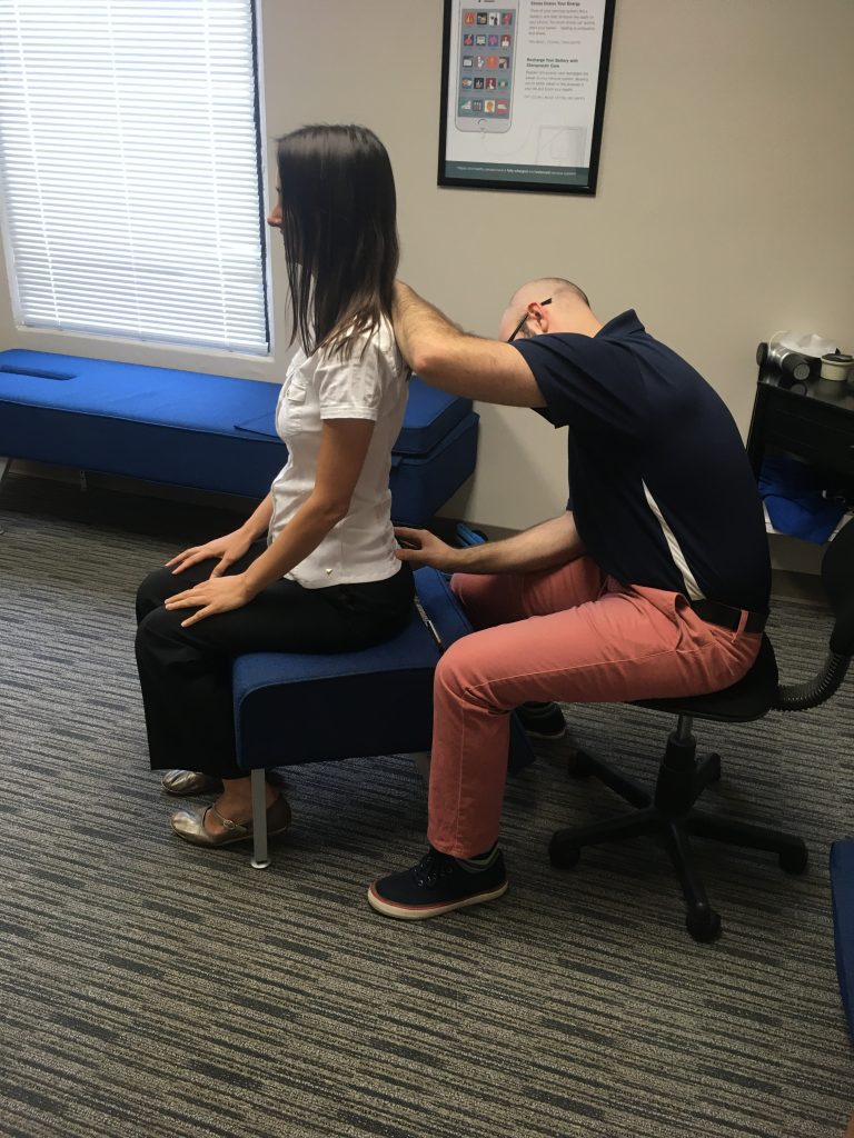 Chiropractor examining lower back after fall injury